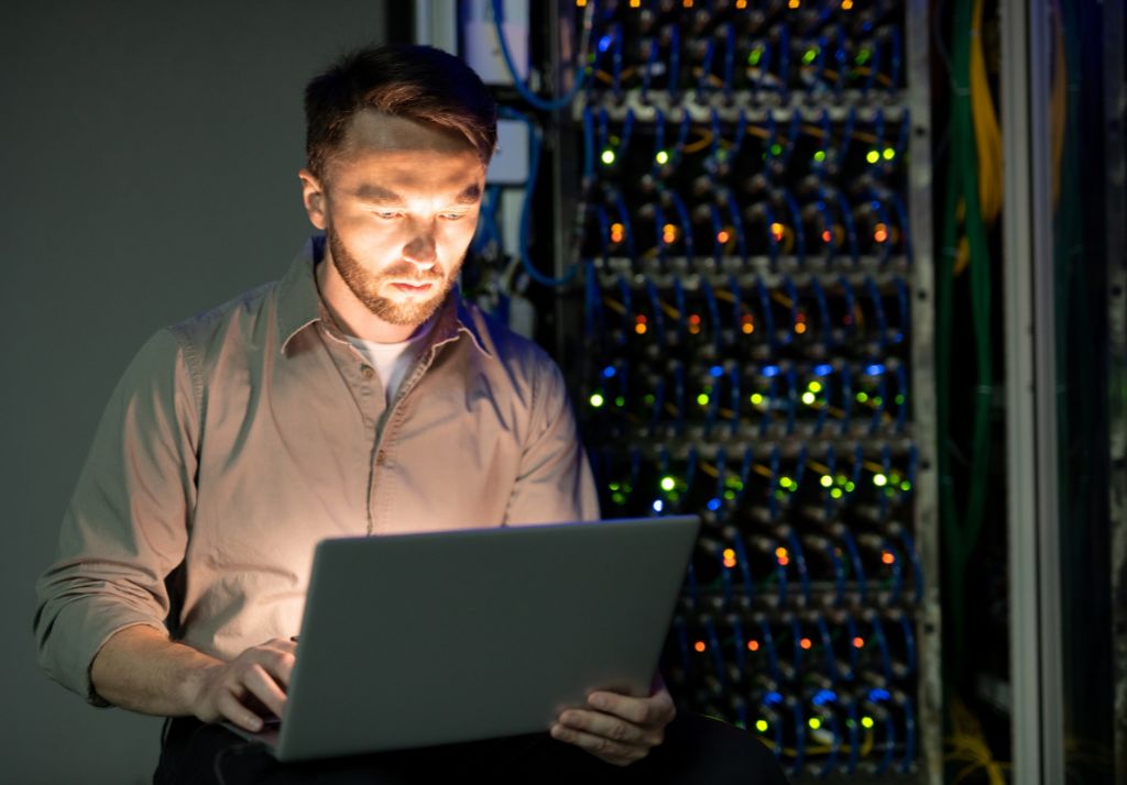 Man using a computer in a server room