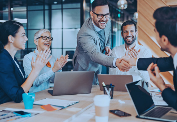 Group of business partners shaking hands and applauding