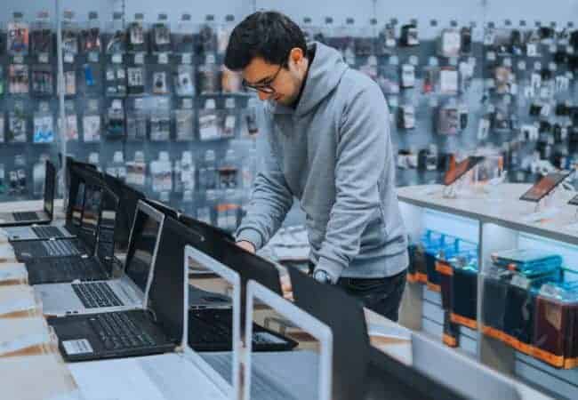 Customer choosing laptop in a computer shop