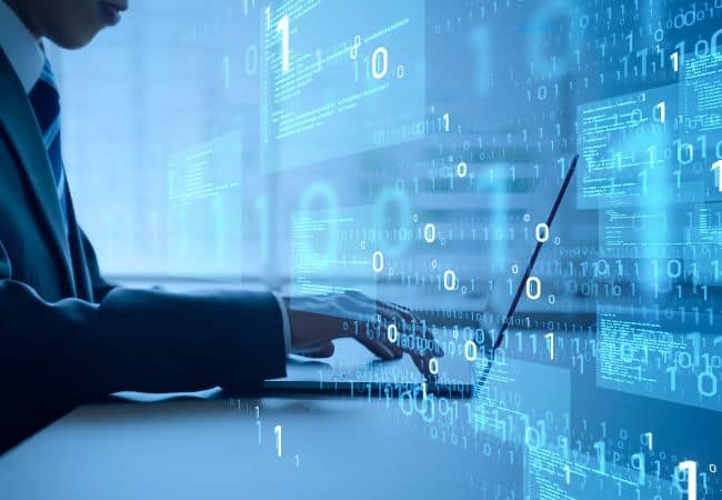 a person in a suit uses a touchscreen tablet while floating binary digits and data code fill the background, suggesting a high tech digital analytics interface